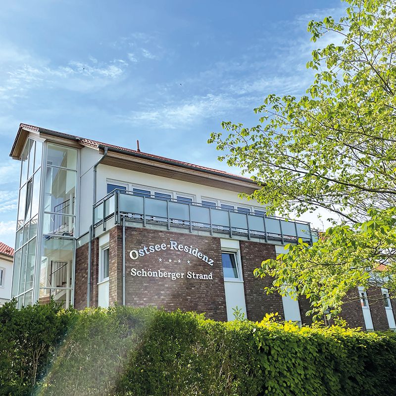 Gebäude Ostseeresidenz Schönberger Strand hinter grüner Hecke