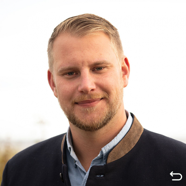Claas Anders im dunkelblauen Jacket vor den Dünen in Hohwacht